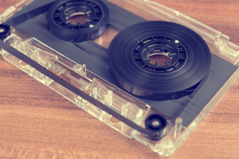 Transparent audio cassette tape on a wooden surface