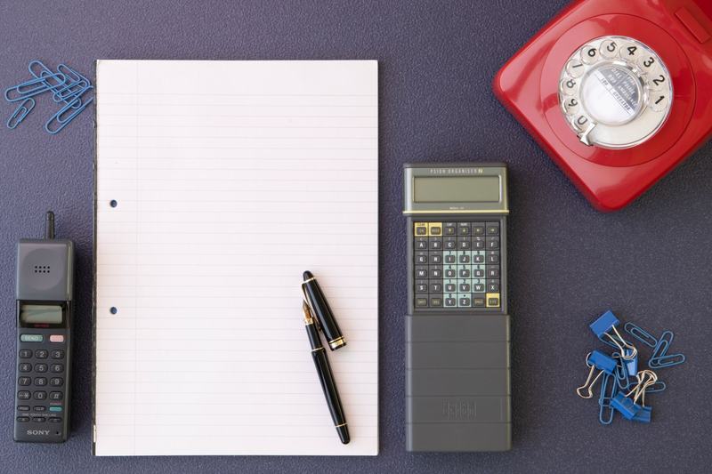 Retro office flat lay with paper, a telephone and a calculator