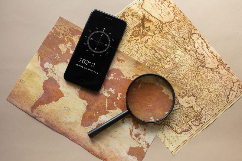Smartphone showing a compass beside an old map