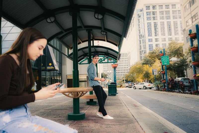 Person checking a phone at a bus shelter