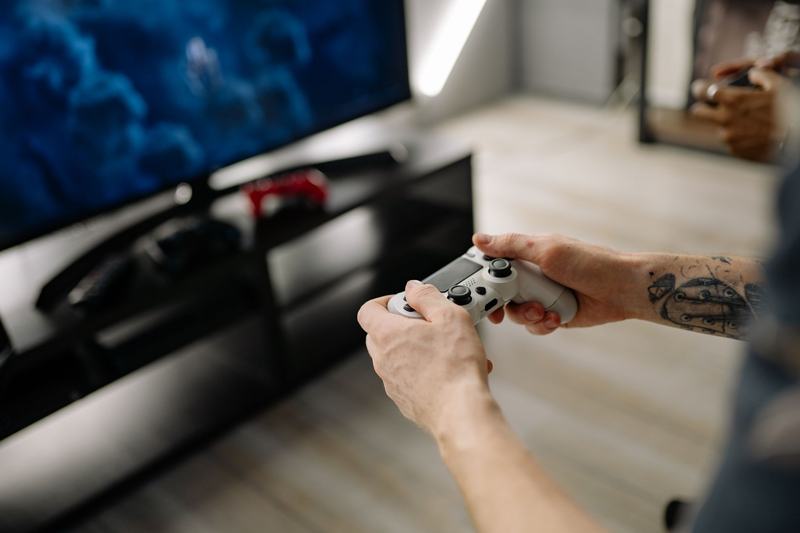 Person holding a game controller in front of a screen