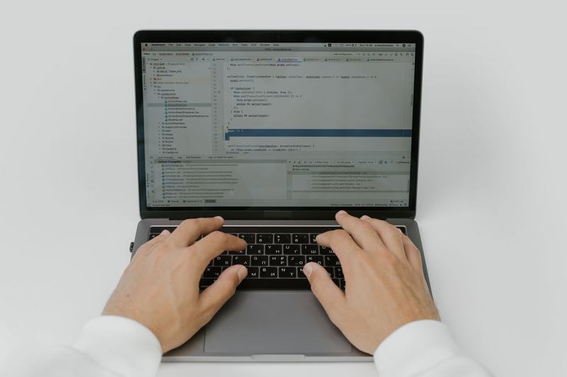 Hands typing on a laptop