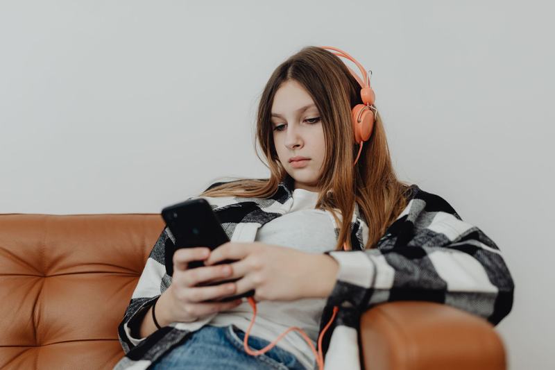 Person listening to music with headphones and a phone